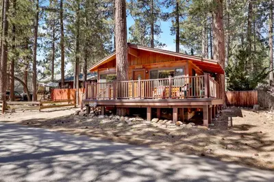 a log cabin in the woods with a tree at Casa Catalina-667 by Big Bear Vacations in Big Bear Lake
