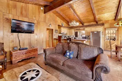 a living room with a brown couch and a tv at Casa Catalina-667 by Big Bear Vacations in Big Bear Lake
