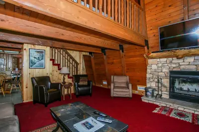 a living room with a fireplace and a flat screen tv at Switzerland Ski Chalet-845 by Big Bear Vacations in Big Bear Lake