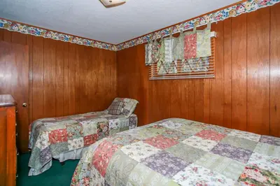 two beds in a room with wooden walls and a window at Avalon Hide Out-1336 by Big Bear Vacations in Big Bear Lake