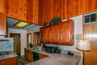 a kitchen with wooden cabinets and a counter top at Avalon Hide Out-1336 by Big Bear Vacations in Big Bear Lake