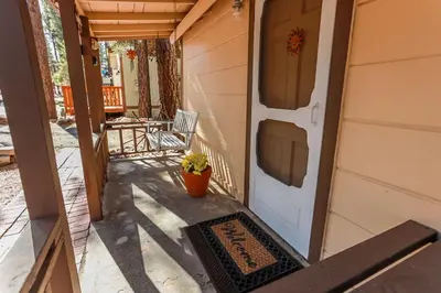 a porch with a white door with a welcome mat at Pines 23-1438 by Big Bear Vacations in Big Bear Lake
