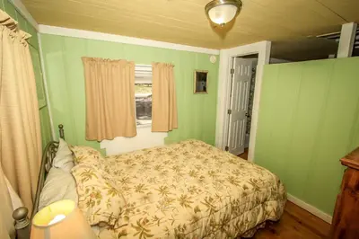 a bedroom with a bed with green walls and a window at Pines 23-1438 by Big Bear Vacations in Big Bear Lake