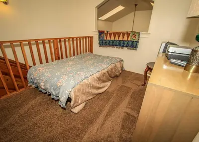 a bedroom with a bed in the corner of a room at Life of Riley-1608 by Big Bear Vacations in Big Bear Lake