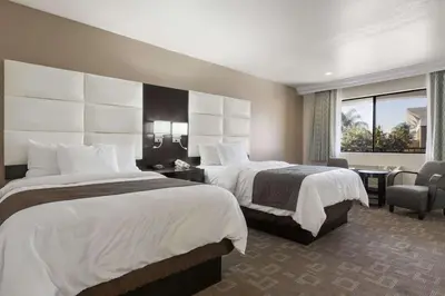 a hotel room with two beds and a window at Days Inn by Wyndham Downey in Downey