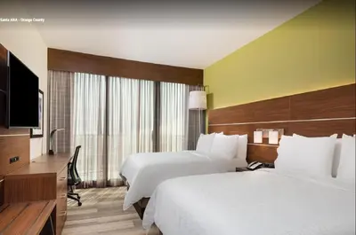 a hotel room with two beds and a flat screen tv at Holiday Inn Express & Suites Santa Ana - Orange County by IHG in Santa Ana