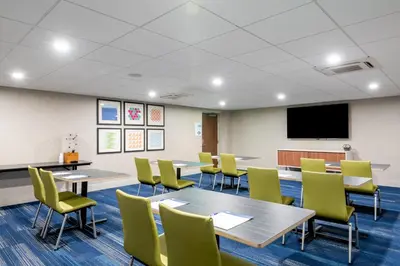 a conference room with tables and chairs and a flat screen tv at Holiday Inn Express & Suites Santa Ana - Orange County by IHG in Santa Ana