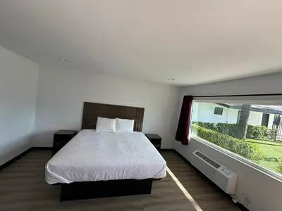 a bedroom with a bed and a large window at Hyland Inn Van Nuys in Van Nuys