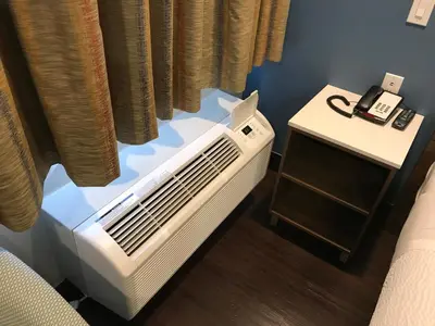 a room with a heater and a phone on a table at Hyland Inn Brea in Brea