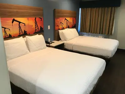 two beds in a hotel room with white sheets at Hyland Inn Brea in Brea