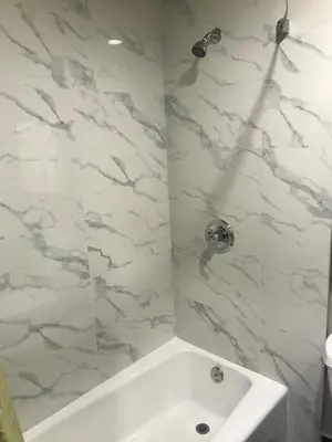 a white bathroom with a tub and a sink at Hyland Inn Brea in Brea