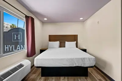 a small bedroom with a bed and a window at Hyland Inn Long Beach in Long Beach