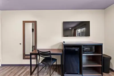a room with a desk with a microwave and a television at Hyland Inn Long Beach in Long Beach