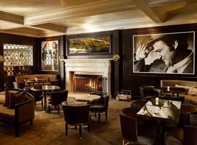 a restaurant with a fireplace and tables and chairs at Hotel Bel-Air - Dorchester Collection in Los Angeles