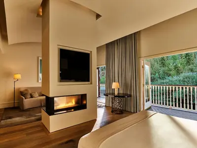 a living room with a fireplace and a television at Hotel Bel-Air - Dorchester Collection in Los Angeles