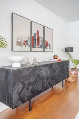 a black console table in a living room with three pictures on the wall at Enchanting Sherman Oaks Home With Pool permit #HSR two five zero zero 3222 in Sherman Oaks