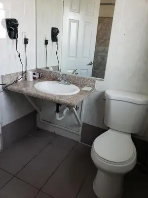 a bathroom with a white toilet and a sink at Eagle Inn Motel in Long Beach