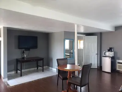 a living room with a table and chairs and a television at Eagle Inn Motel in Long Beach