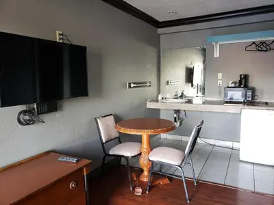 a small table and chairs in a room with a kitchen at Eagle Inn Motel in Long Beach