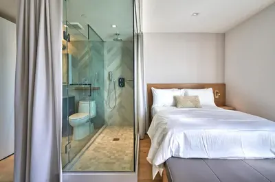 a bedroom with a glass shower and a bed at Mayumi in Los Angeles