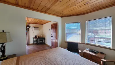 a bedroom with a bed and two windows and a desk at Kernville Inn in Kernville