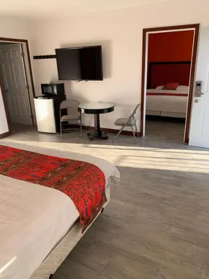 a bedroom with a bed and a table and a tv at norwalk inn & suites in Norwalk