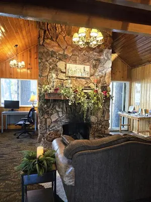 a stone fireplace in a living room with a couch at Big Bear Frontier in Big Bear Lake
