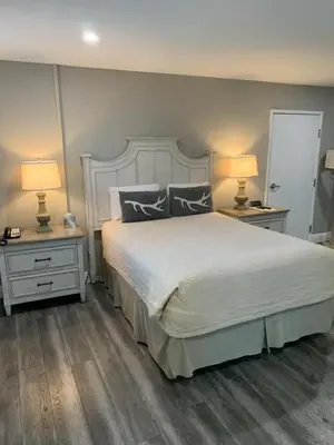 a bedroom with a bed and two night stands with lamps at Big Bear Frontier in Big Bear Lake
