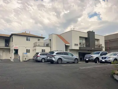 a parking lot with cars parked in front of a building at Motel 6 Glendale CA Pasadena Burbank Los Angeles in Glendale