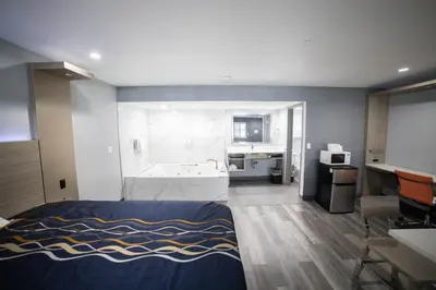 a bedroom with a bed and a bathroom with a tub at Travelodge by Wyndham Whittier in Whittier