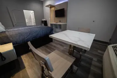 a room with a bed and a table and a desk at Travelodge by Wyndham Whittier in Whittier