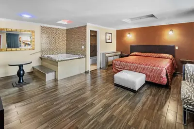 a hotel room with a bed and a bath tub at Sky Palm Motel - Orange in Orange