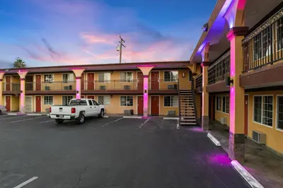 a building with a white truck parked in a parking lot at Sky Palm Motel - Orange in Orange