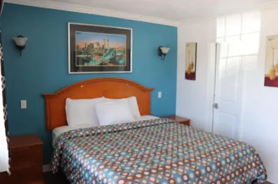 a bedroom with a bed with blue walls at El Dorado Motel in Gardena