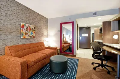 a living room with a couch and a bedroom at Home2 Suites by Hilton Victorville in Victorville