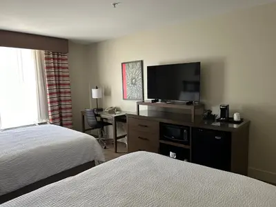 a hotel room with a bed and a desk with a television at Holiday Inn & Suites - Barstow by IHG in Barstow