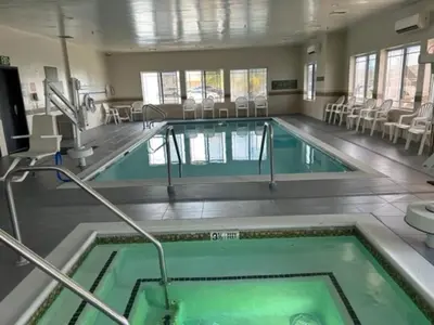 a swimming pool with green water in a building at Holiday Inn & Suites - Barstow by IHG in Barstow