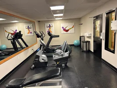 a gym with treadmills and ellipticals in a room at Holiday Inn & Suites - Barstow by IHG in Barstow