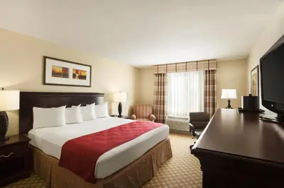 a hotel room with a large bed and a desk at Holiday Inn & Suites - Barstow by IHG in Barstow