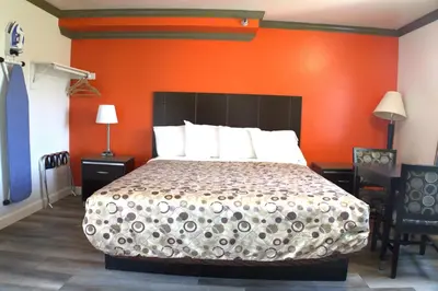 a bedroom with a bed with an orange wall at Lambert Inn in Whittier