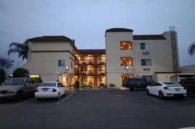 a large building with cars parked in a parking lot at Lambert Inn in Whittier