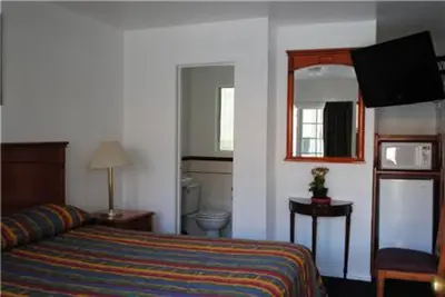 a hotel room with a bed and a mirror at Rose Bowl Motel in Los Angeles