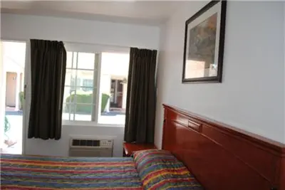 a bedroom with a couch and a window and a bed at Rose Bowl Motel in Los Angeles