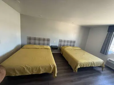 two beds in a room with yellow covers on them at Vista Motel in Los Angeles