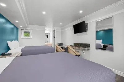 a hotel room with two beds and a tv at Rodeway Inn Commerce - Los Angeles in Commerce