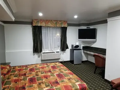 a hotel room with a bed and a flat screen tv at Rodeway Inn Commerce - Los Angeles in Commerce