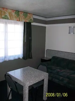 a living room with a table and a couch at Rodeway Inn Commerce - Los Angeles in Commerce