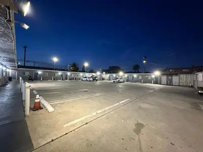 a parking lot at night with cars parked in it at Sand Piper Motel - Los Angeles in Los Angeles