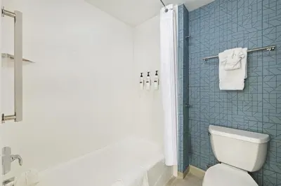 a bathroom with a toilet and a shower with blue tiles at Homewood Suites Lancaster in Lancaster