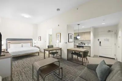 a hotel room with a bed and a living room at Homewood Suites Lancaster in Lancaster